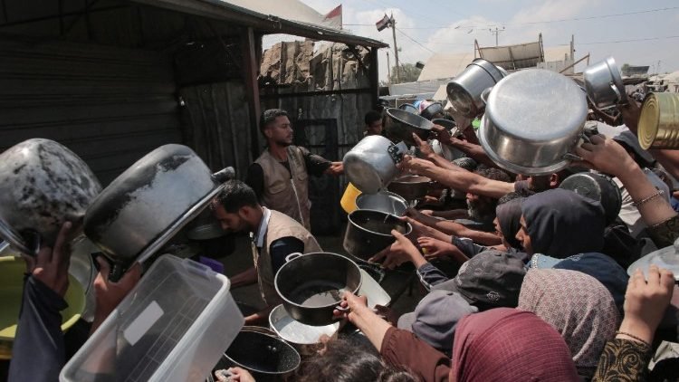 Palestinos muestran sus ollas vacías en un comedor de beneficencia en Khan Yunis, en Gaza (AFP or licensors) (AFP or licensors)